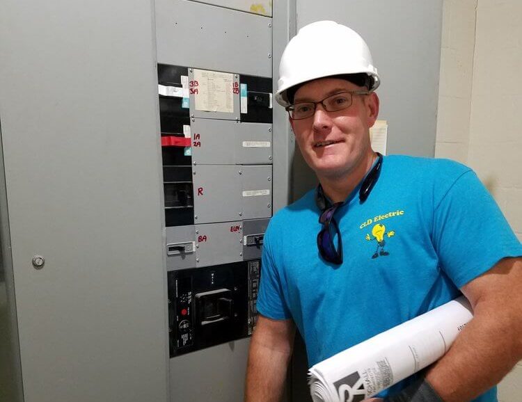 electrician standing next to commercial panel
